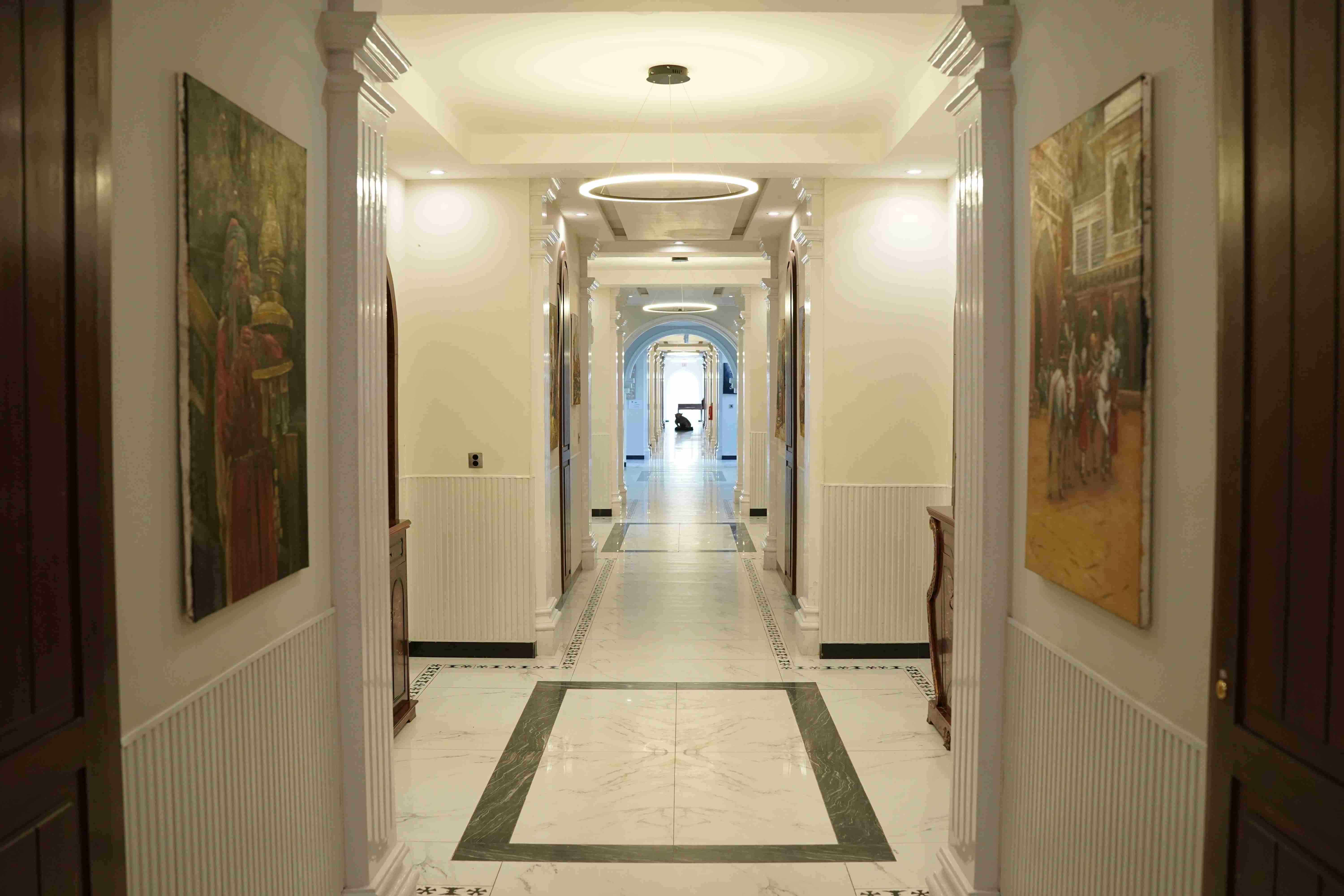 Marble hallway with art and pendant lighting